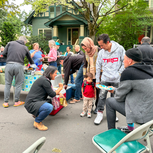 Teacher Tiffany talking to a child at a block party.