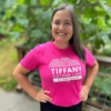 A woman in a pink t-shirt with "Tiffany Koyama Lane for City Council" written on it.