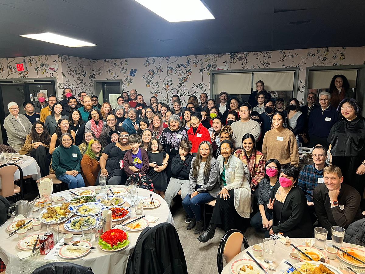 A large group of smiling people at a resturant.